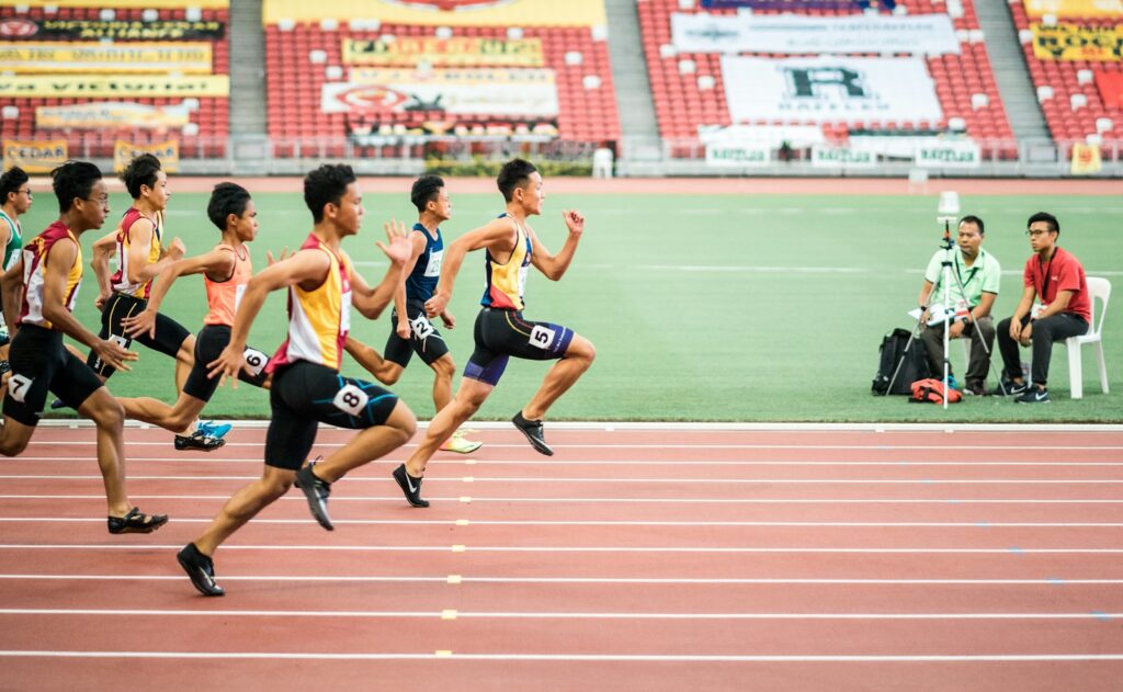 Lauf-ABC im Stadion: Gruppe von Läufern trainiert auf einer Laufbahn