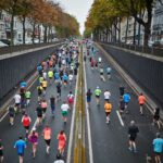 Teilnehmende eines Stadtmarathons auf breiter Straße am Ende ihrer Marathon-Vorbereitung