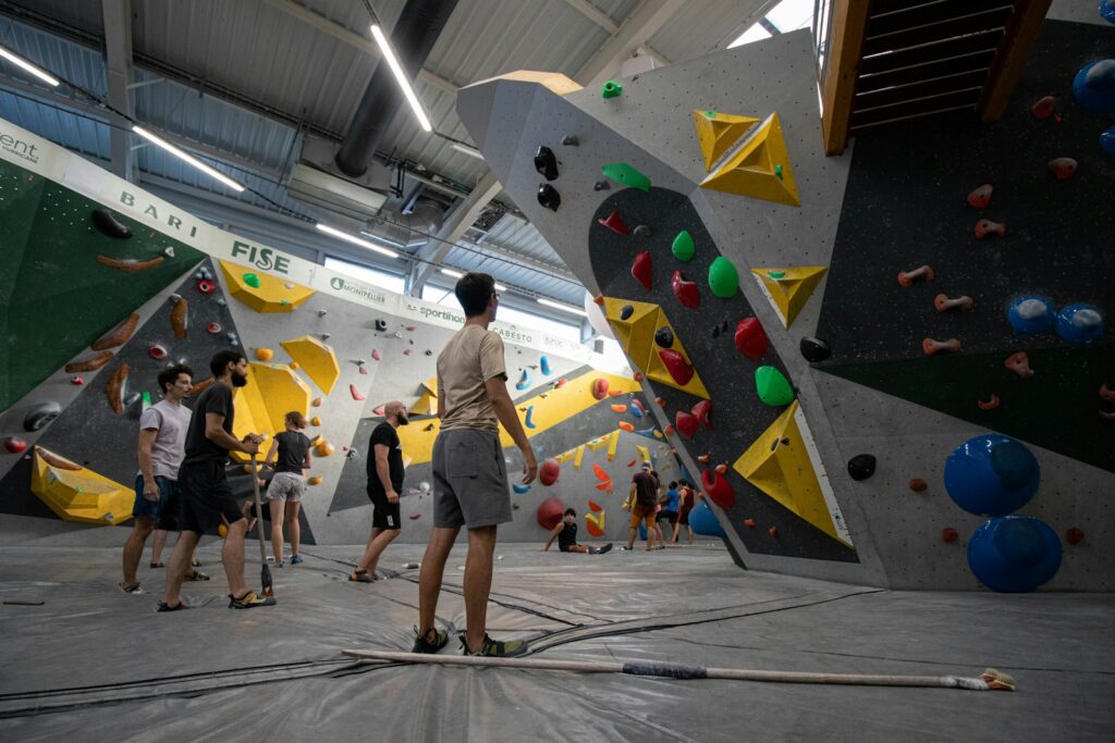 Kletterer studiert vor dem Bouldern die Griffe einer Route in der Halle