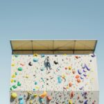 Bouldern Schwierigkeitsgrade: Person klettert an einer bunten Boulderwand im Freien