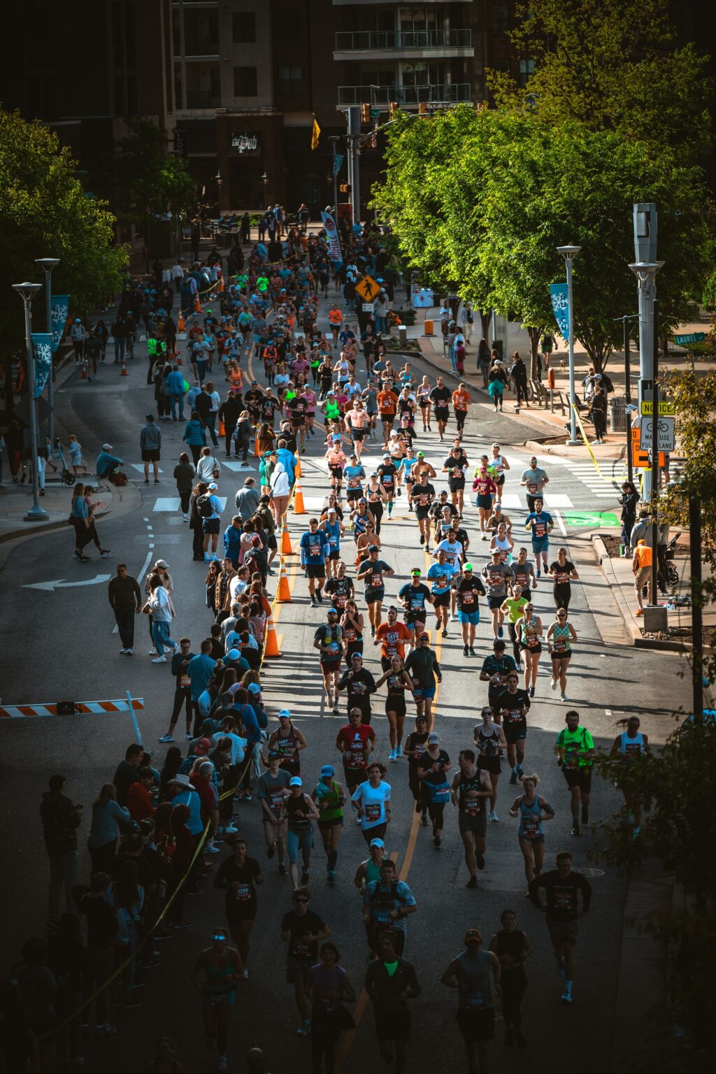 Läuferinnen und Läufer bei einem Straßenlauf auf einer breiten Straße in der Stadt