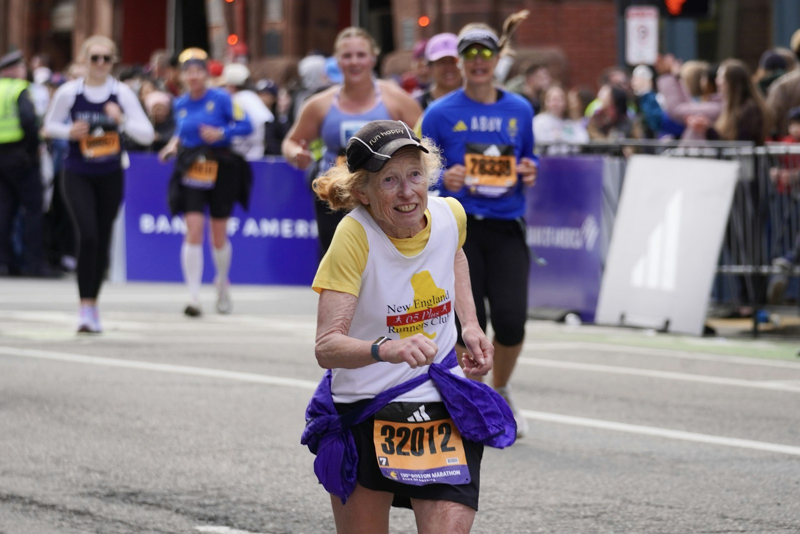 Ältere Läuferin lächelt im Rennen, Halbmarathon Zeiten nach Alter fair einordnen