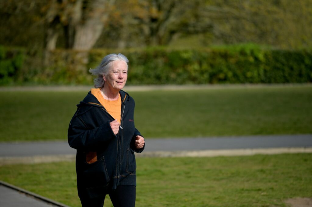 Ältere Frau joggt im Park, Halbmarathon Zeiten nach Alter im Hobbybereich