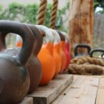 Reihe Kettlebells verschiedener Größe auf Holz zeigt die Stufen beim Kettlebell-Gewicht