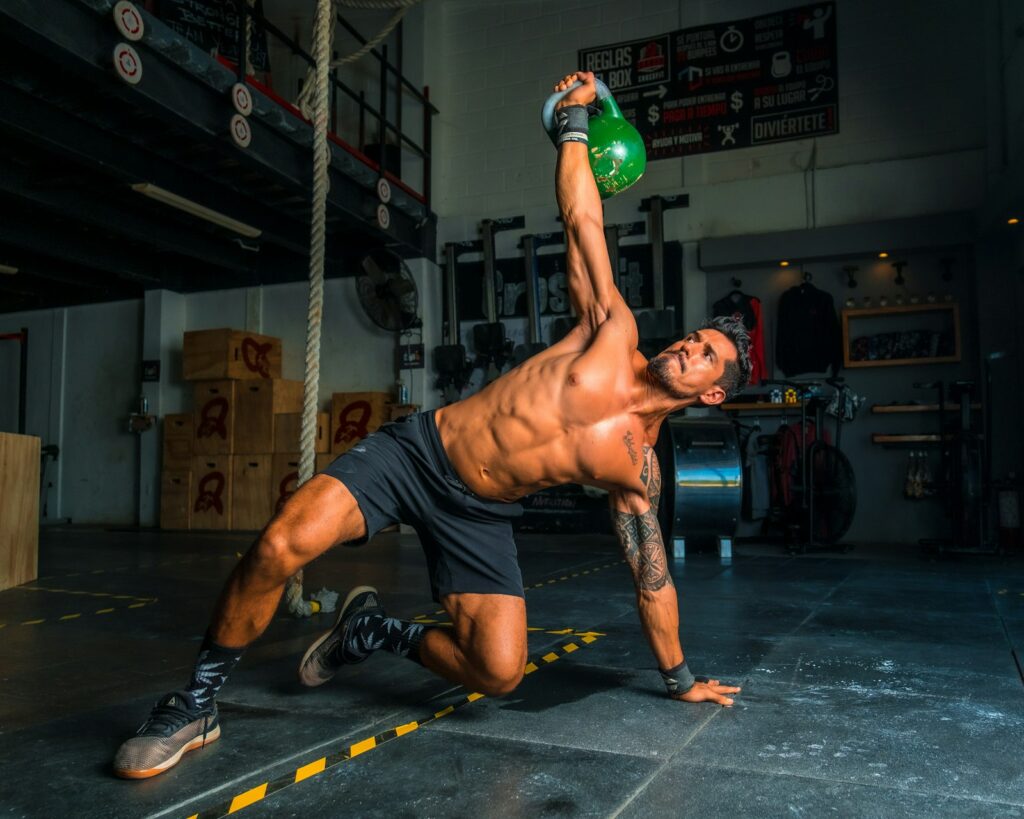 Mann macht im Fitnessstudio einen Turkish Get-up mit einer leichteren Kettlebell