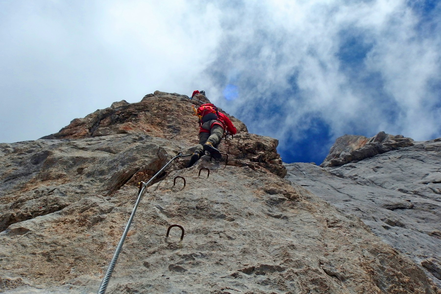 Bergsteiger am Drahtseil eines Klettersteigs am Dachstein