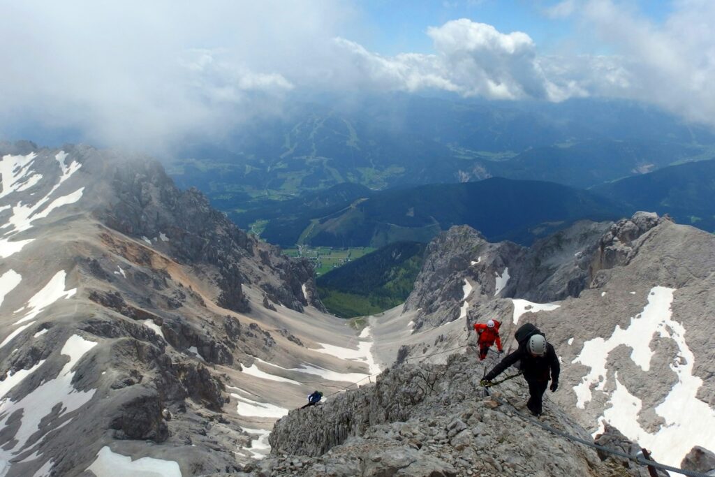 Zwei Personen an einem gesicherten Felssteig in der Dachsteinregion, Beispiel für Klettersteig Schwierigkeitsgrade