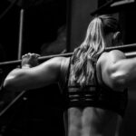 Frau hebt eine Langhantel, Krafttraining für Frauen im Studio