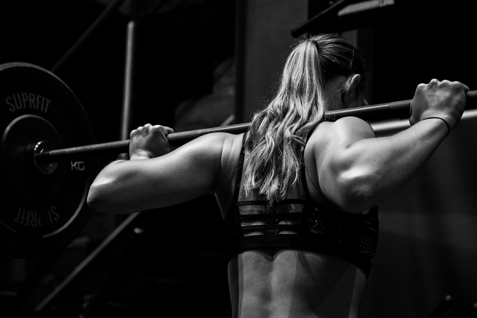 Frau hebt eine Langhantel, Krafttraining für Frauen im Studio