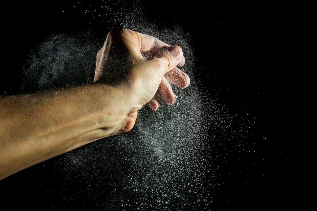 Hand mit Chalk-Pulver als Alternative zu Handschuhen im Training