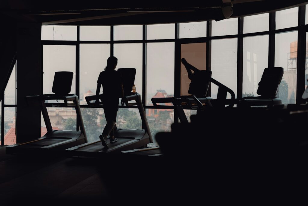 Silhouette eines Mannes beim Laufen auf einem Laufband im Fitnessstudio