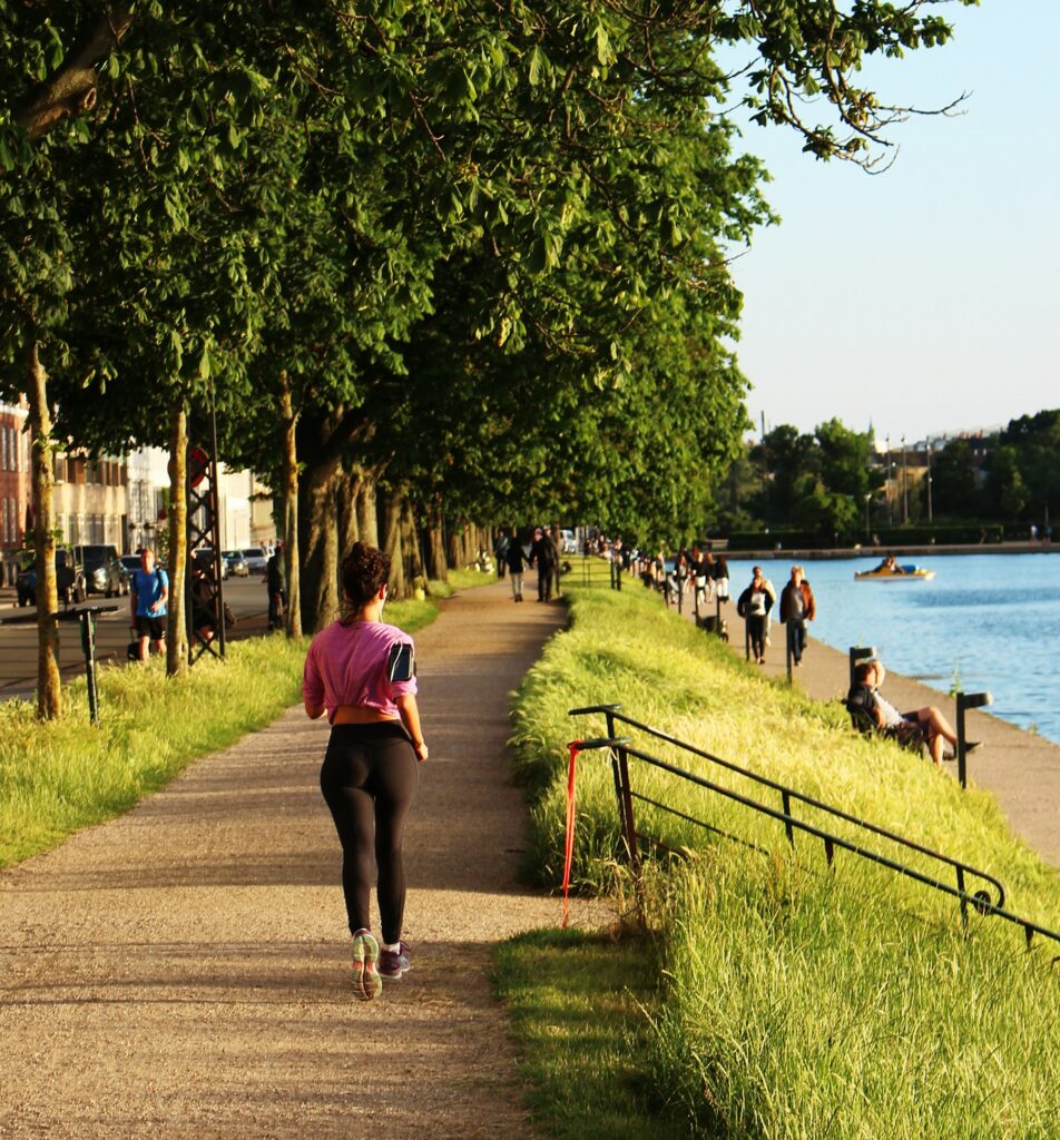 Frau joggt in einem Park am Wasser entlang