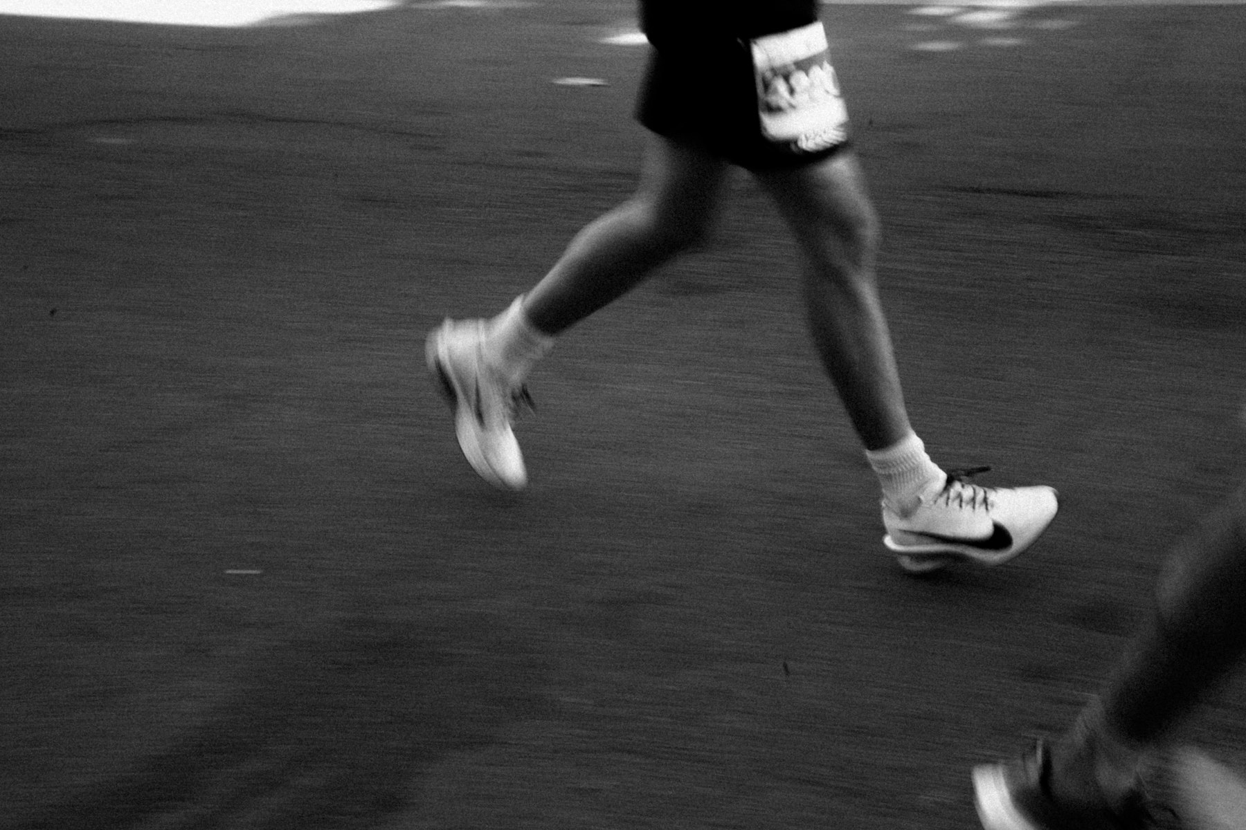 Lauftechnik im Rennen: Nahaufnahme von Beinen und Laufschuhen eines Läufers in Bewegung