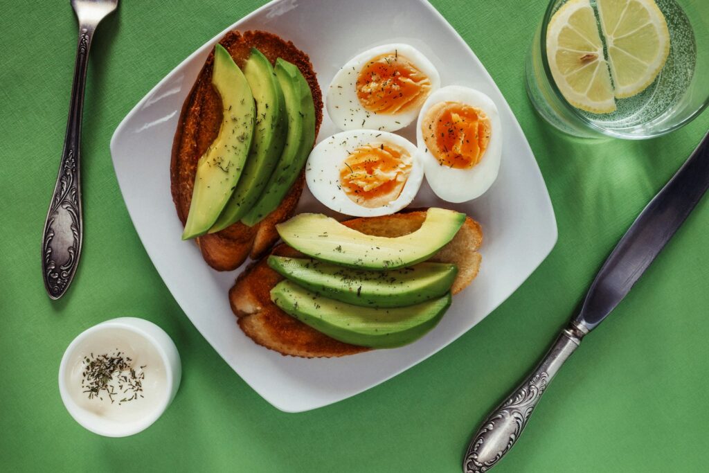 Offene Brote mit Avocado und Ei auf weißem Teller