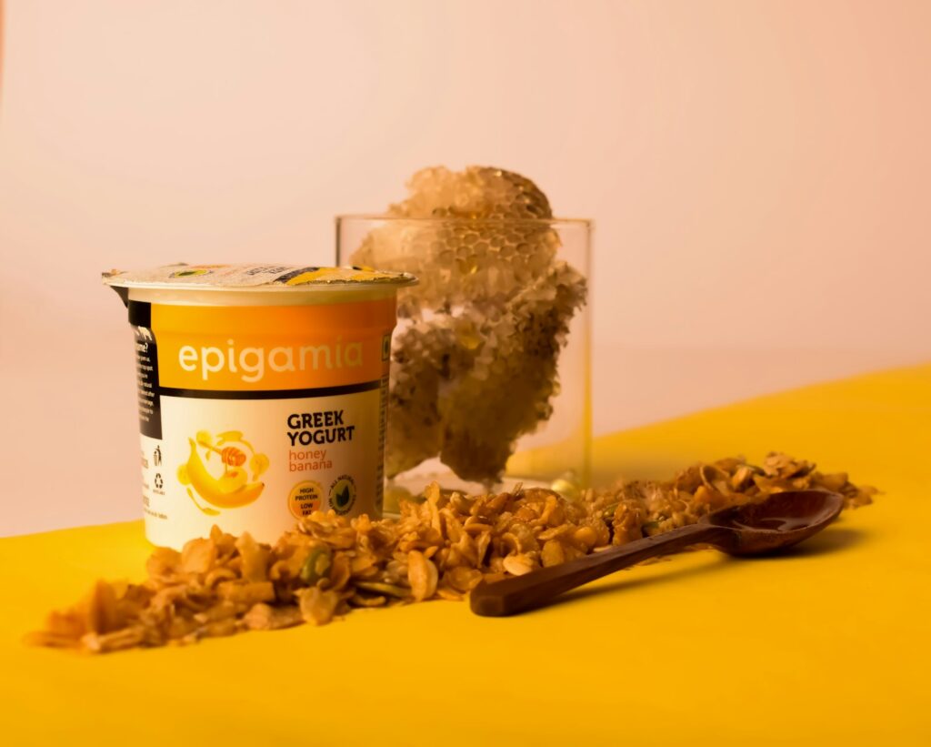 Joghurt mit Granola und Honig in einer Schale mit Löffel