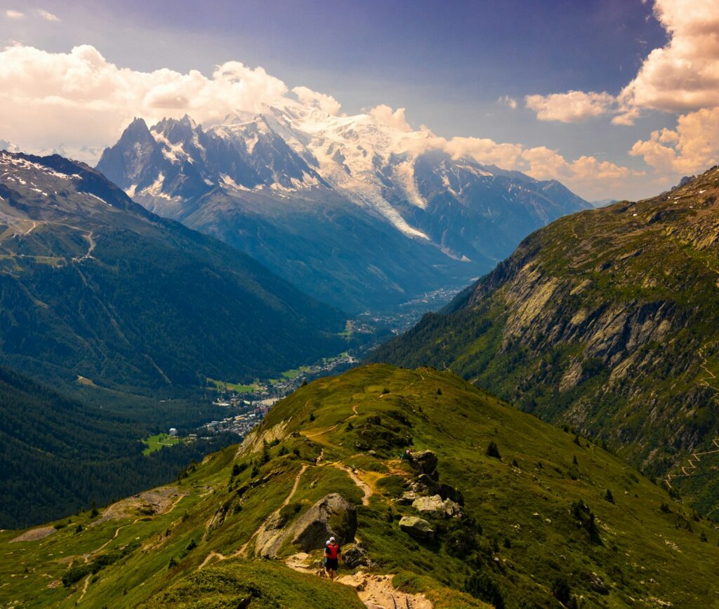 Zwei Läufer beim Trailrunning auf einem grünen Bergpfad vor dem Mont-Blanc-Massiv