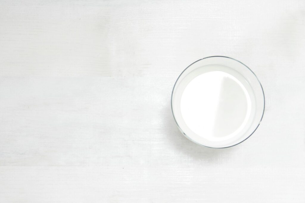Glas Milch auf einem weißen Holztisch